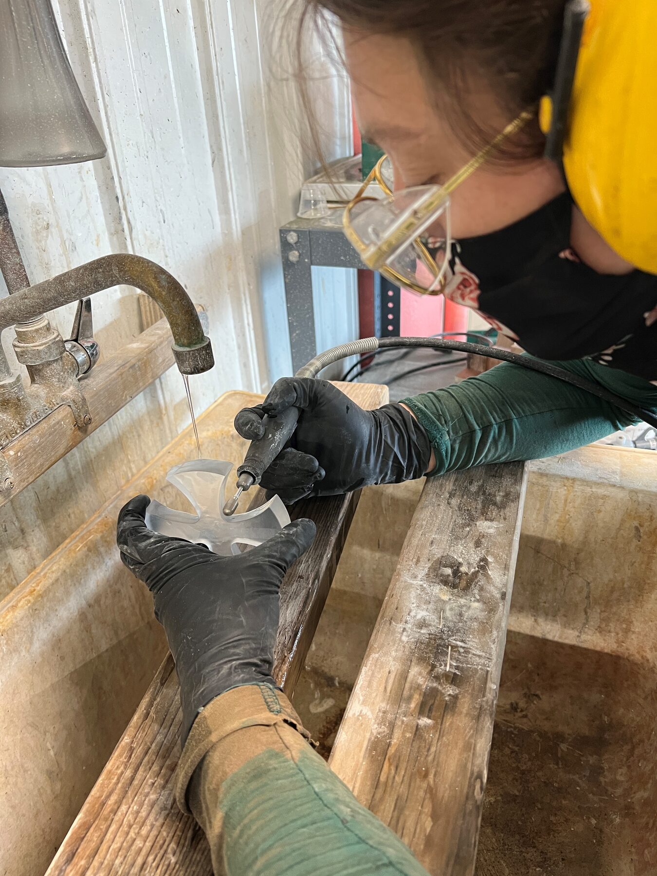 Hand working a glass cross